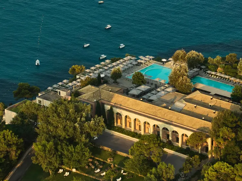 Vue aérienne d'un complexe hôtelier avec piscine et végétation luxuriante.
