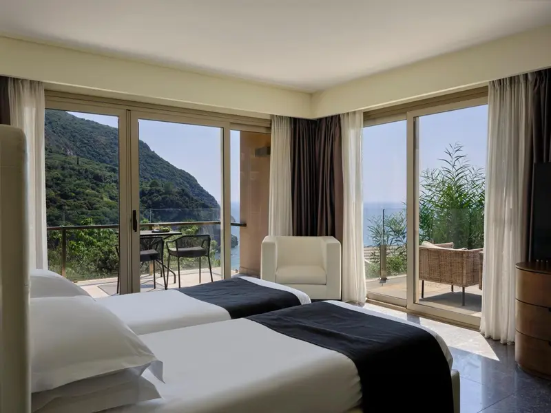 Chambre lumineuse avec vue sur la mer et une terrasse.