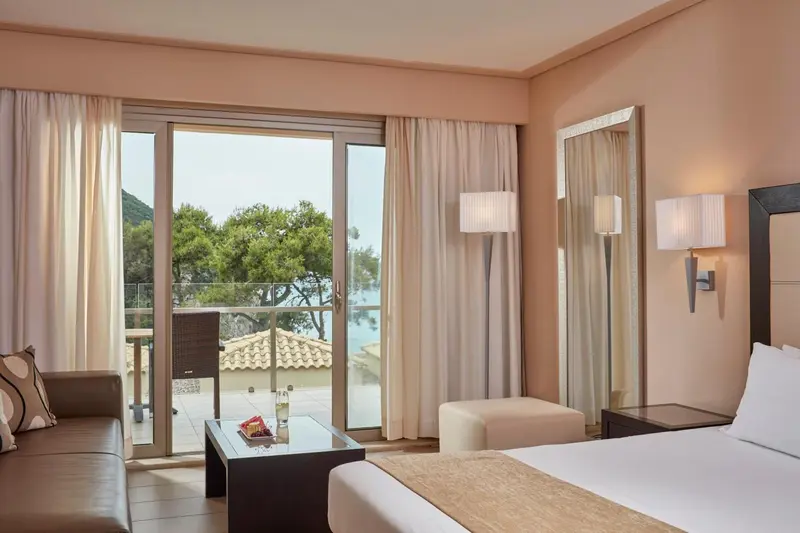Une chambre lumineuse avec un canapé et un accès à un balcon.