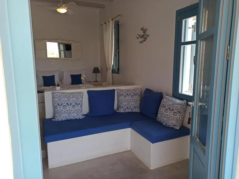 Espace de détente avec canapé d'angle bleu et coussins décoratifs.