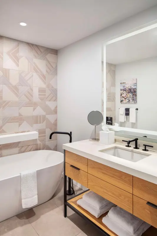 Une salle de bain moderne avec une baignoire et un meuble-lavabo en bois.