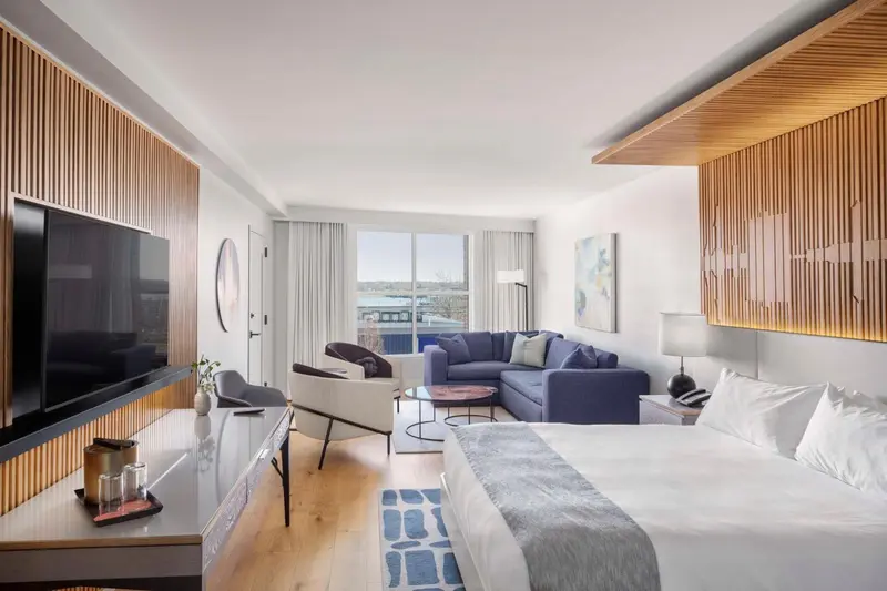 Une chambre moderne avec un coin salon et une vue sur la ville.