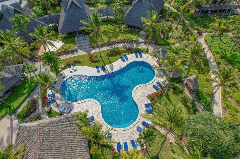 Vue aérienne d'une piscine au sein d'un complexe hôtelier tropical.