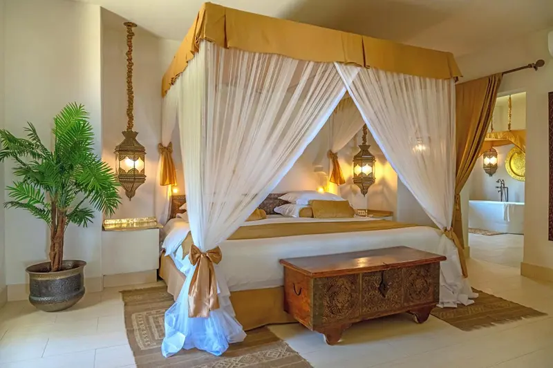 Une chambre lumineuse avec un lit à baldaquin et une décoration soignée.