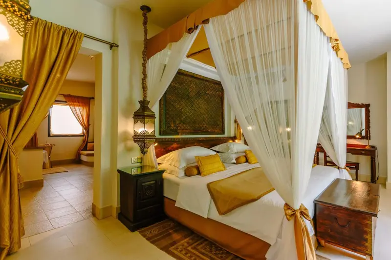 Une chambre à coucher lumineuse avec un lit à baldaquin et une décoration orientale.