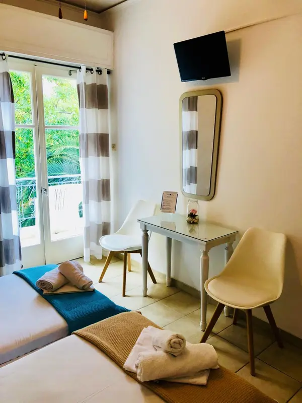 Une chambre lumineuse avec un lit et un coin repos.
