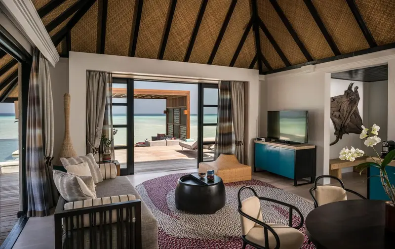 Espace de détente intérieur avec canapés et vue sur l'océan.