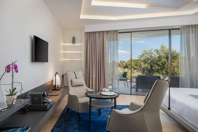 Espace de séjour lumineux avec fauteuils et vue sur l'extérieur.