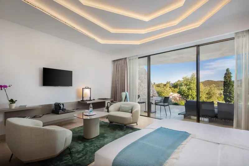 Chambre lumineuse avec un lit confortable et un accès à une terrasse.