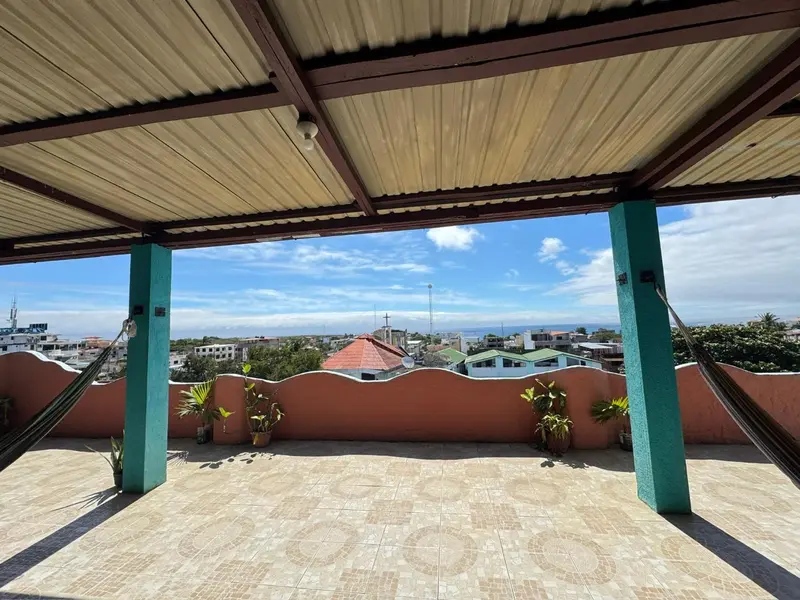 Terrasse ombragée avec vue sur la mer et la ville.