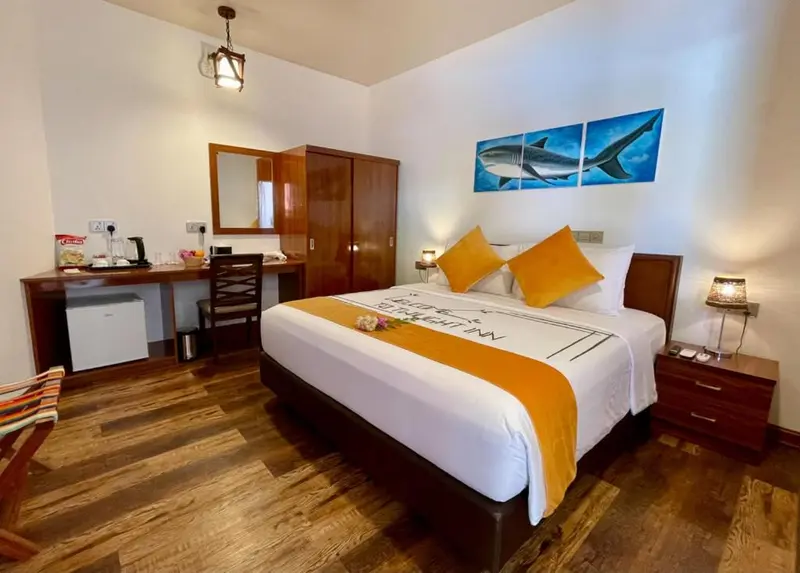 Une chambre lumineuse avec un grand lit et des tableaux décoratifs.