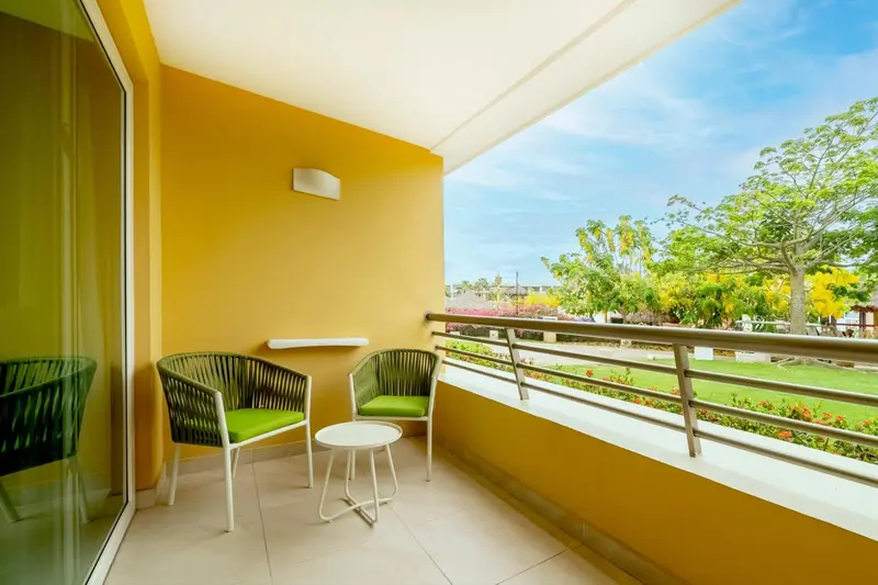 Terrasse avec mobilier d'extérieur et vue sur un jardin verdoyant.