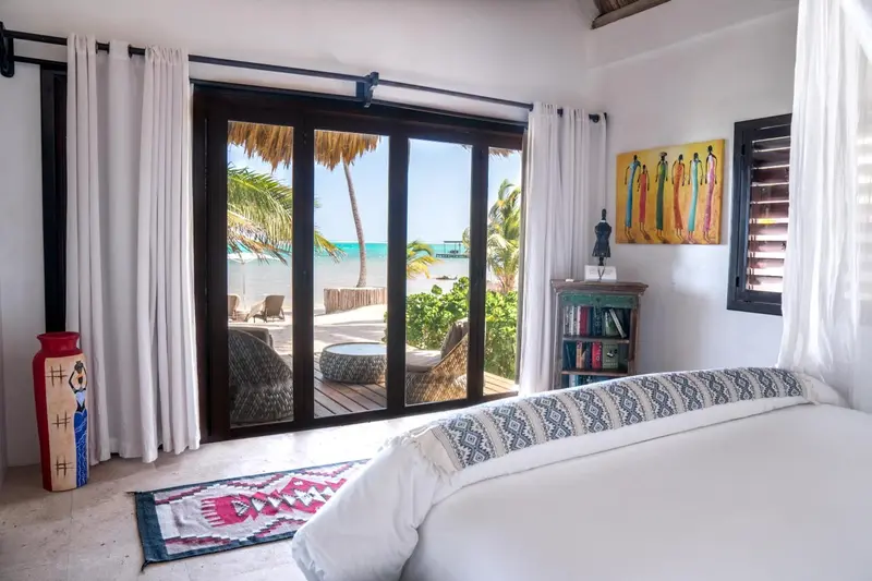 Une chambre lumineuse s'ouvre sur une terrasse avec vue sur la mer.