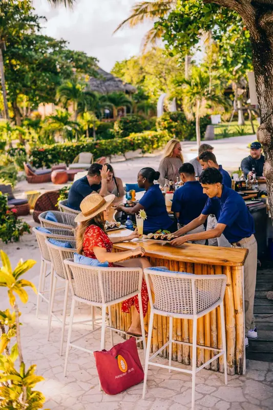 Des clients sont servis au comptoir d'un bar en bord de mer.