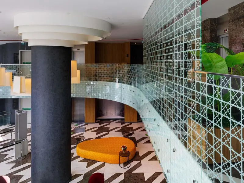 Hall d'entrée moderne avec sol à motifs géométriques et mobilier design.