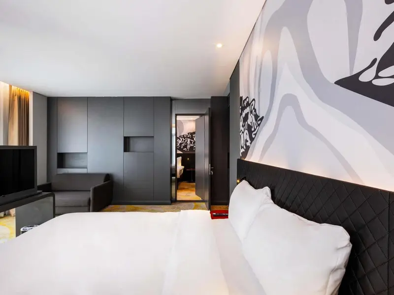 Une chambre moderne avec un grand lit et un mur décoratif.