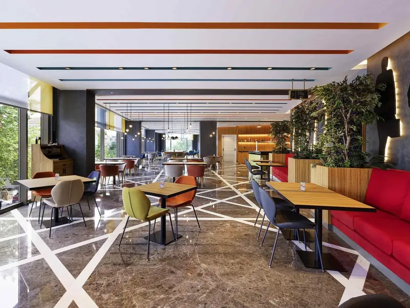 Une salle de restaurant lumineuse avec des tables et des chaises colorées.