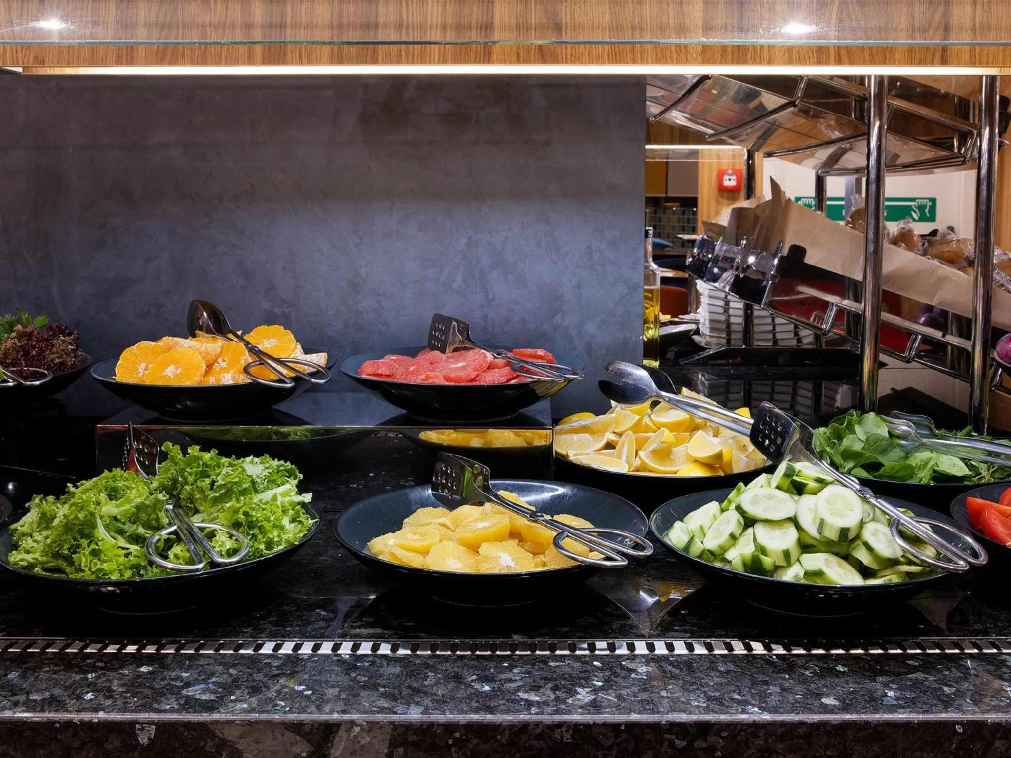 Un buffet propose une variété de salades et de fruits frais.