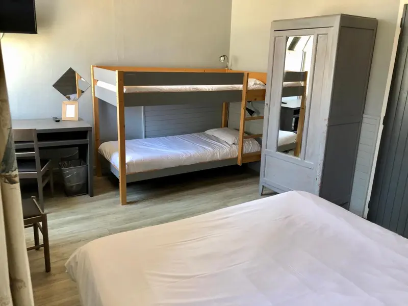 Une chambre avec un lit superposé et un bureau.