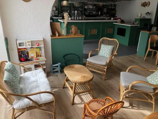 Espace de détente avec mobilier en rotin et jeux d'enfants.
