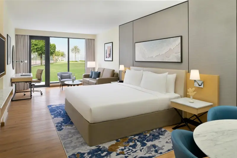 Une chambre lumineuse avec un grand lit et un coin salon.