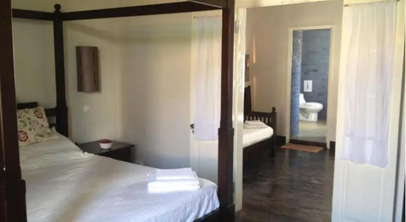 Une chambre avec un lit à baldaquin et une salle de bain attenante.
