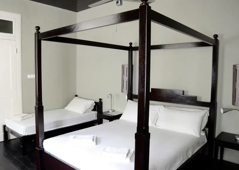 Une chambre avec un lit à baldaquin et une table de chevet.