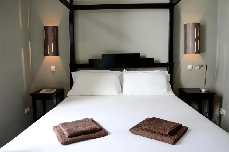 Un lit double avec une tête de lit en bois sombre et des oreillers blancs.