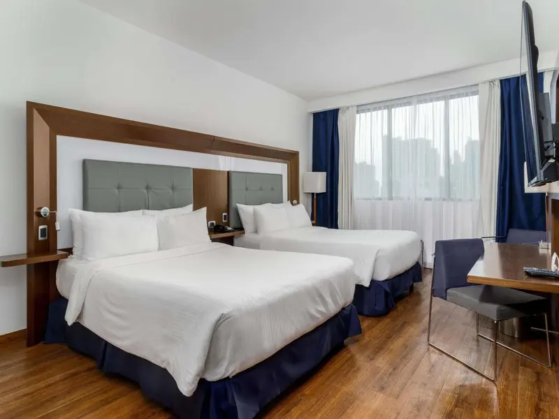 Une chambre d'hôtel avec deux lits et un bureau.