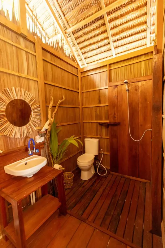 Une salle de bain rustique en bois avec douche et lavabo.