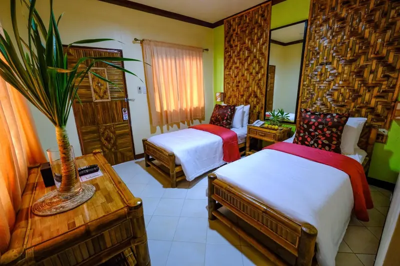 Chambre lumineuse avec deux lits simples et décoration en bois.