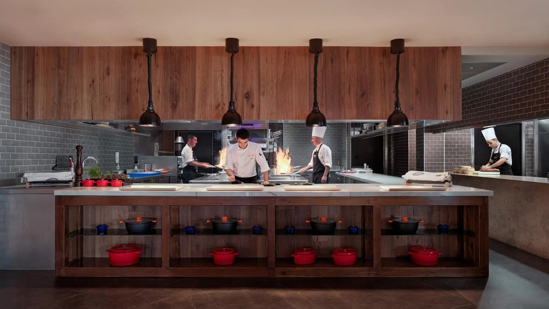 Cuisine professionnelle avec des chefs préparant des plats sur un îlot central.