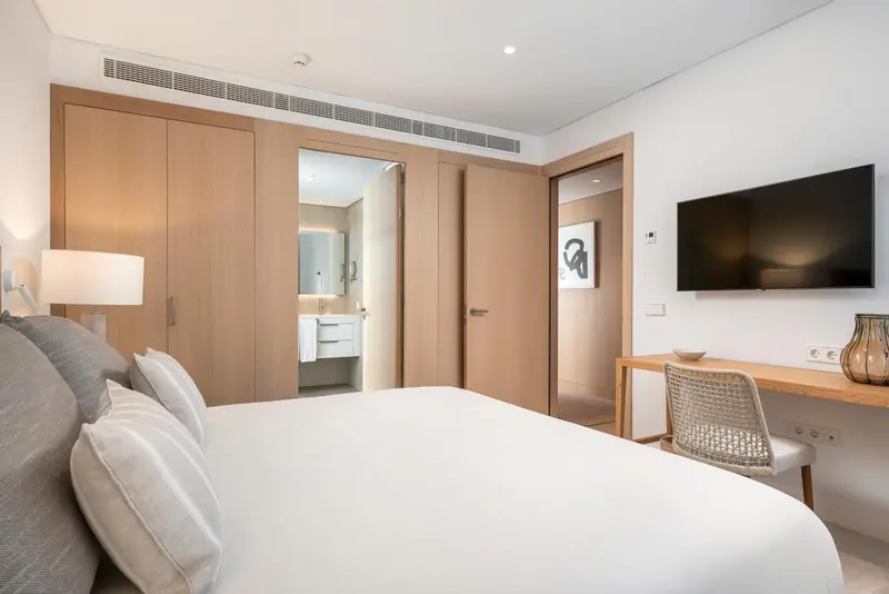 Une chambre lumineuse avec un grand lit et un bureau.