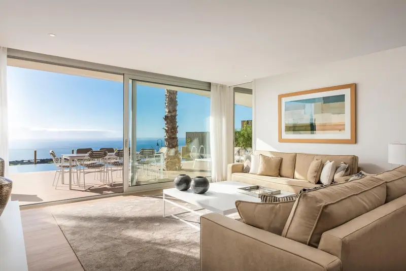Un salon lumineux s'ouvre sur une terrasse avec vue sur la mer.