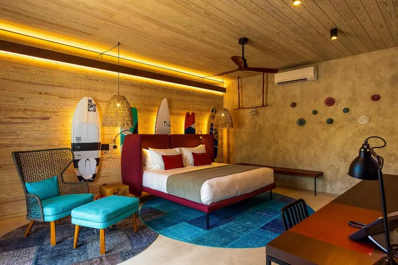 Une chambre lumineuse avec un lit double et des éléments de décoration sur le thème du surf.