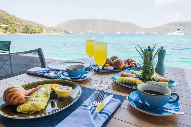 Une table est dressée avec un petit-déjeuner face à la mer.