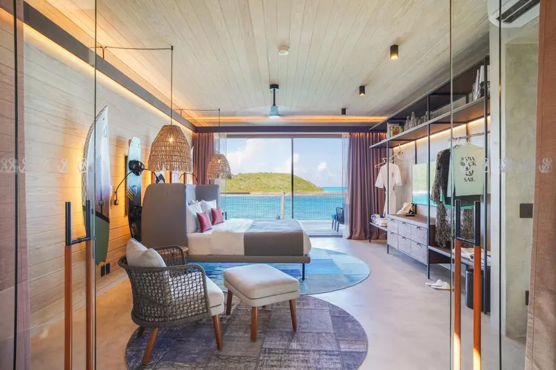 Une chambre lumineuse avec un lit king-size donnant sur la mer.