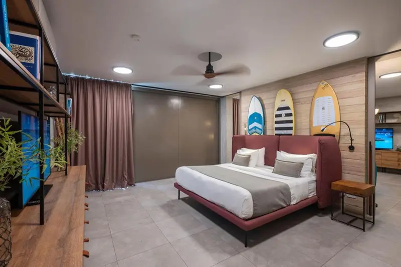 Une chambre avec un grand lit et des planches de surf décoratives.