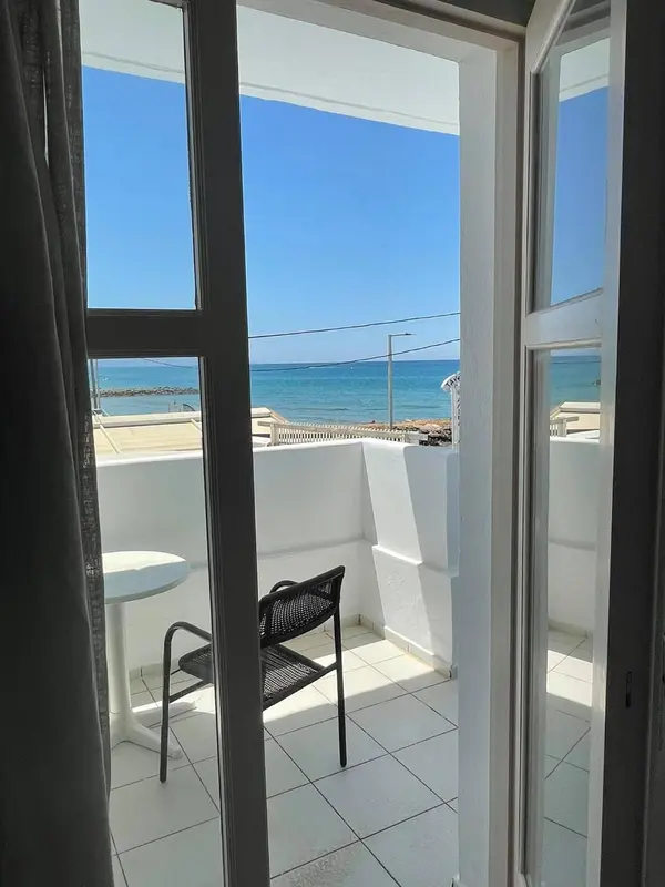 Vue sur la mer depuis une terrasse carrelée avec une table et une chaise.