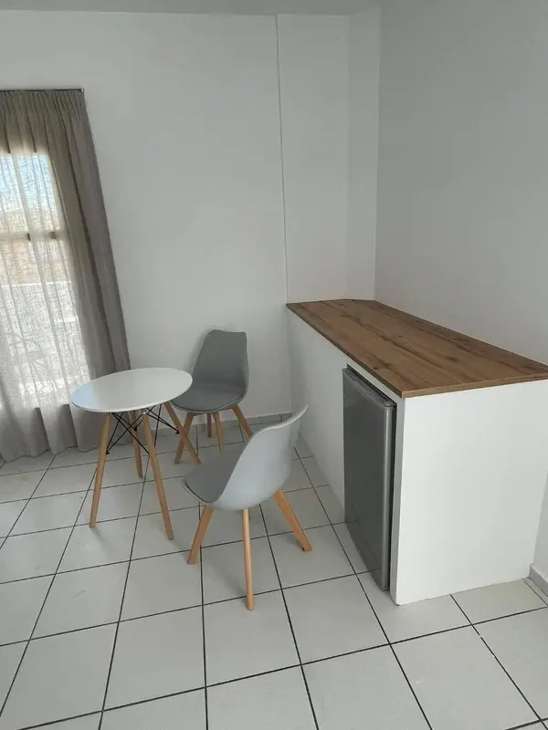 Une table et des chaises se trouvent dans une pièce lumineuse.