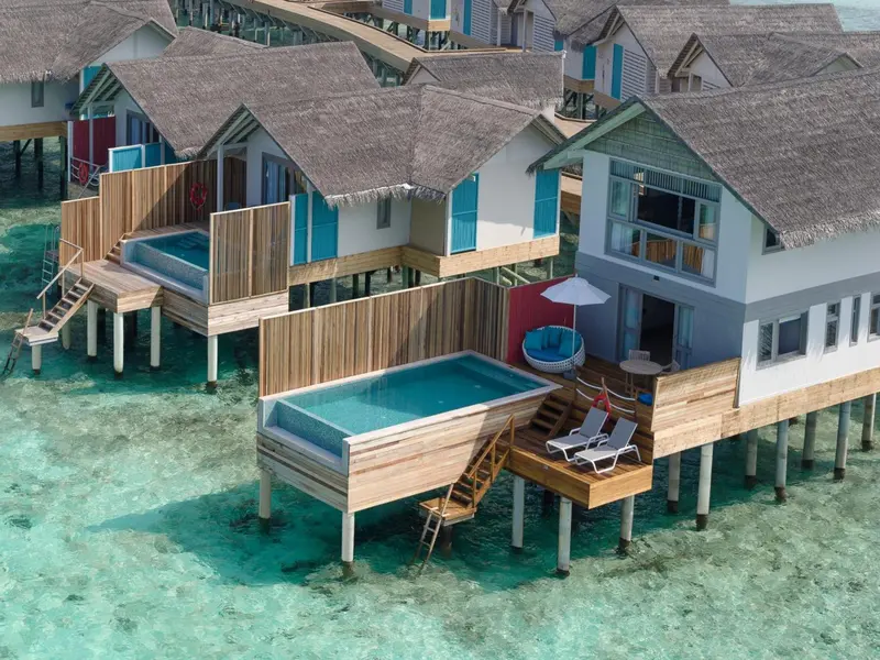 Vues aériennes de villas sur pilotis avec piscines privées et terrasses.
