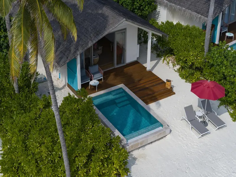 Une terrasse en bois avec piscine privée et mobilier de jardin.
