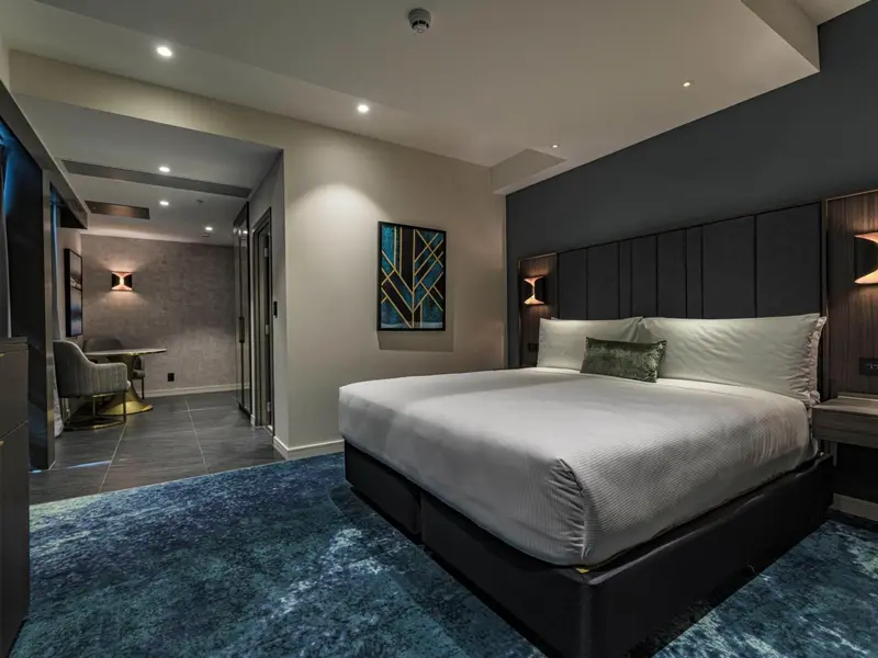 Une chambre spacieuse avec un grand lit et un coin repas.