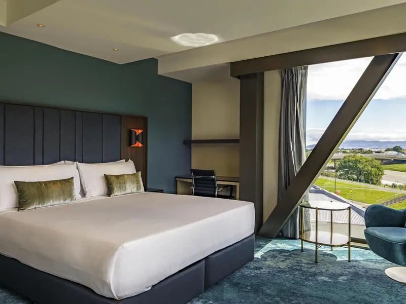 Une chambre avec un grand lit et une vue sur la ville.