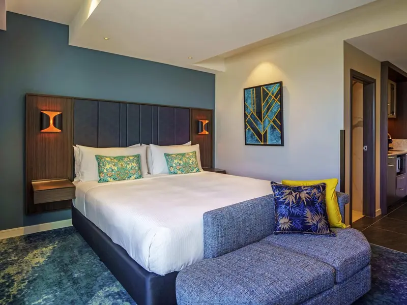Une chambre moderne avec un grand lit et un coin salon.