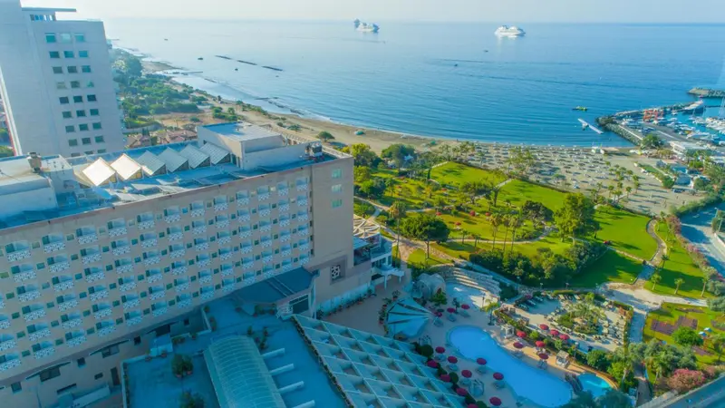Vue aérienne d'un complexe hôtelier avec piscine et accès à la plage.
