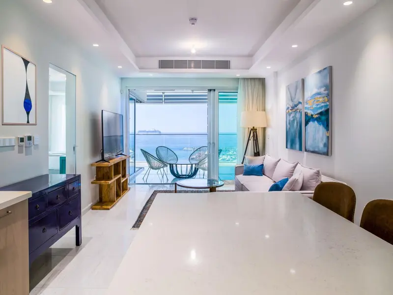 Espace de vie lumineux avec canapé et vue sur la mer.