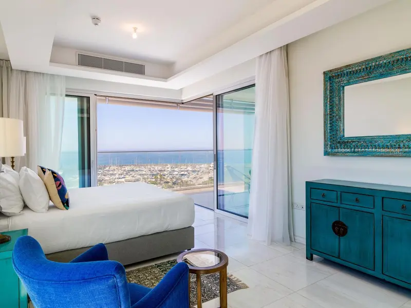 Une chambre lumineuse avec un grand lit et une vue sur la mer.
