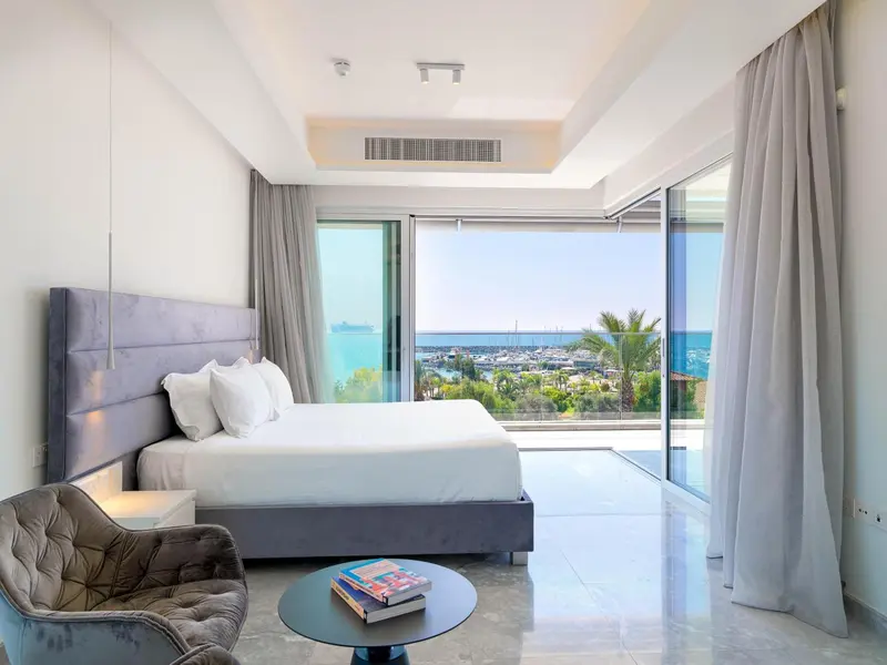Une chambre lumineuse avec un grand lit et une vue sur la mer.