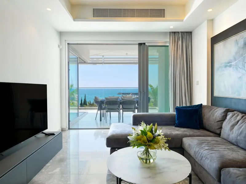 Un salon lumineux s'ouvre sur une terrasse avec vue sur la mer.